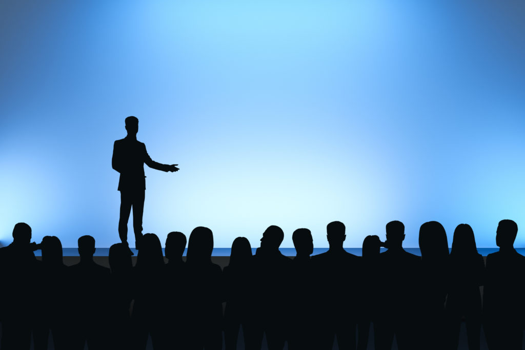 Risk takers make good leaders, Man Giving Speech In Front Of Backlit Audience On Light