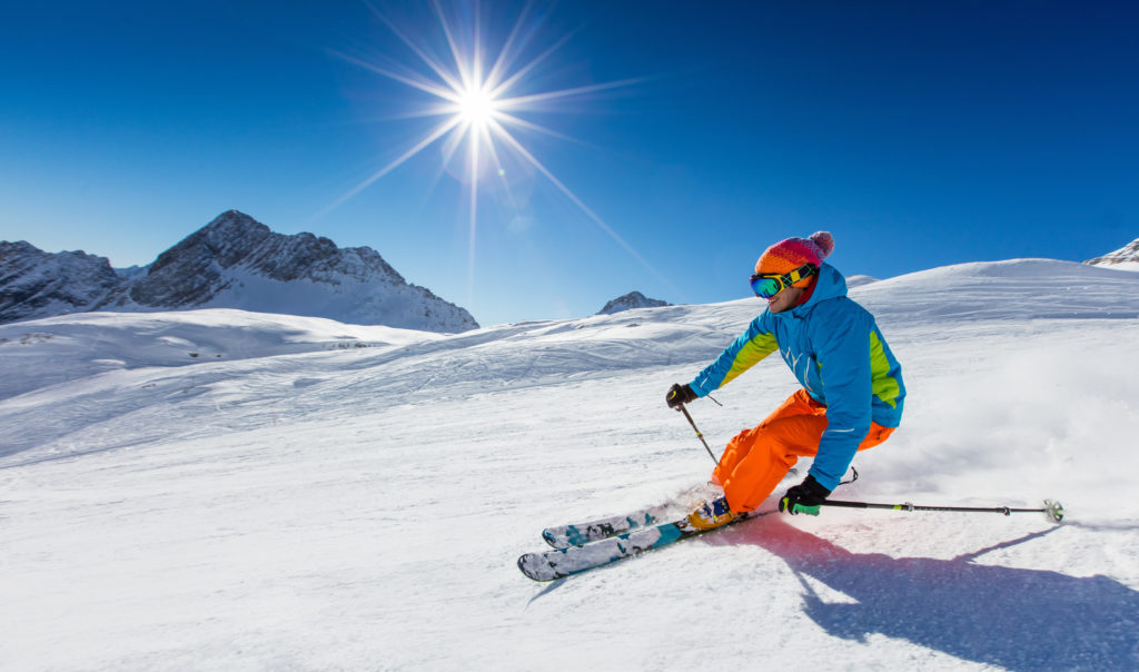 Skier,Skiing,Downhill,During,Sunny,Day,In,High,Mountains
